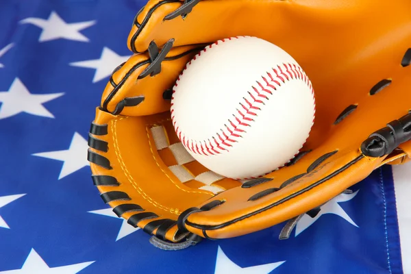 Baseballová rukavice a míč na pozadí americké vlajky — Stock fotografie