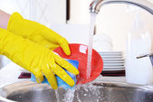 Zblízka ruce ženy mytí nádobí v kuchyni