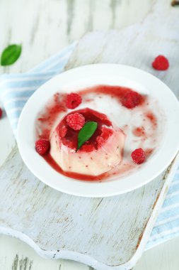 Panna cotta ahşap zemin üzerinde frambuaz sos ile