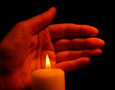 Yanan Mum ve el üstünde siyah izole