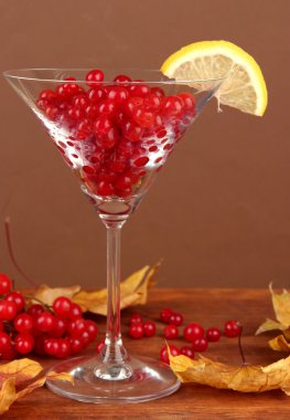 Kartopu cam ve tablo kahverengi zemin üzerine sarı yapraklar kırmızı meyveler