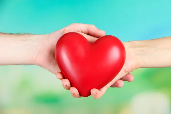 Corazón en manos en el fondo de la naturaleza — Foto de Stock