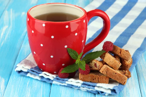 Kopje thee met koekjes en frambozen op tabel close-up — Stockfoto