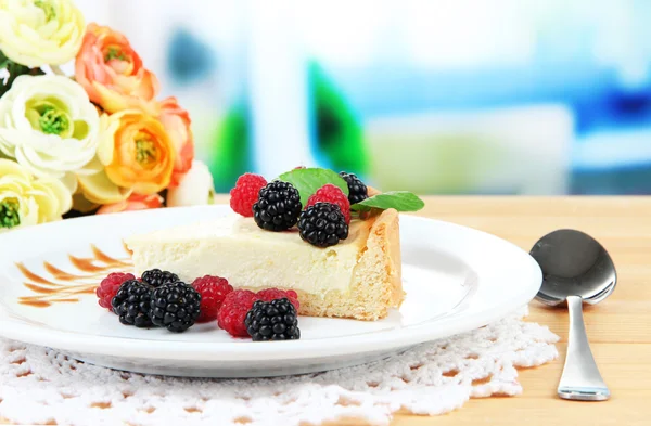 Slice of cheesecake with raspberry and blackberry on plate, on bright background — Stock Photo, Image