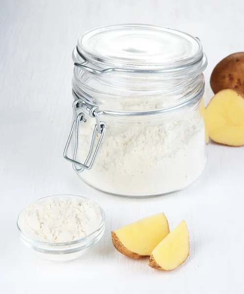 Starch in bowl and bank on wooden table close-up — Stock Photo, Image