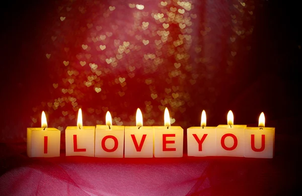 Candles with printed sign I LOVE YOU, on blur lights background — стоковое фото