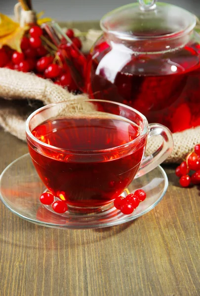 Still life with viburnum tea on sackcloth napkin, on wooden background — Stock Photo, Image