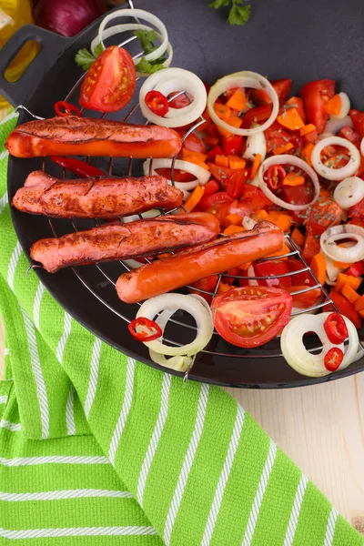 Deliciosas salchichas con verduras en wok sobre mesa de madera de cerca — Foto de Stock