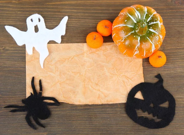 Old paper with Halloween decorations on grey wooden background — Stock Photo, Image