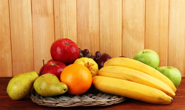 Composition of different fruits on table on wooden background — Stock Photo, Image