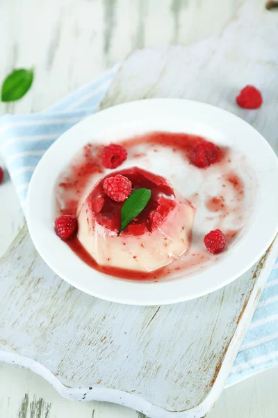 Panna cotta mit Himbeersoße, auf Holzgrund — Stockfoto