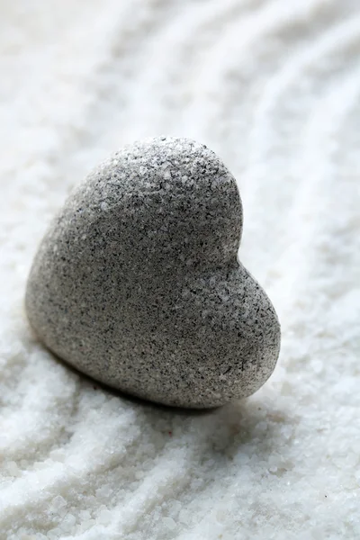 灰色の砂の背景にハートの形で禅石 — ストック写真