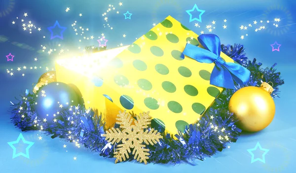 Gift box with bright light on it on blue background — Stock Photo, Image