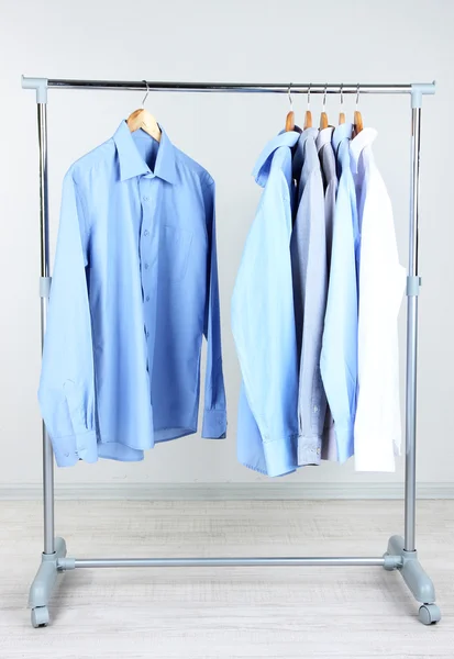 Biuro męskiego ubrania na wieszakach, na szarym tle — Zdjęcie stockowe