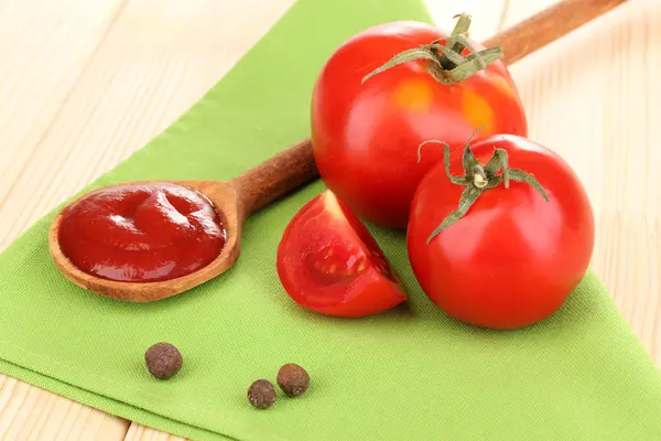 Ketchup and ripe tomatoes on wooden table — Stock Photo, Image