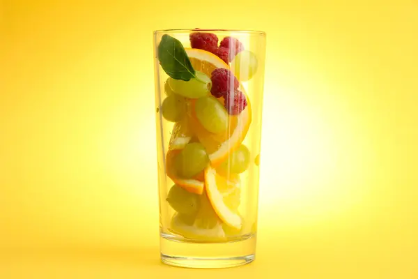 Przezroczyste szkło z owoców cytrusowych, na żółtym tle — Zdjęcie stockowe