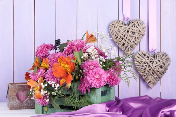 Композиция цветов в ящике с украшениями на столе на деревянном фоне — стоковое фото