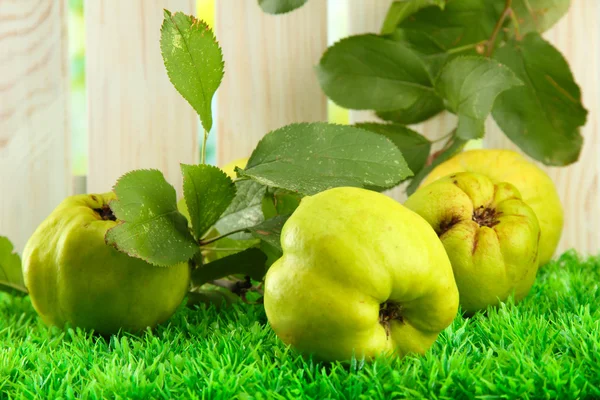 Sweet quinces with leaves, on grass — Stock Photo, Image