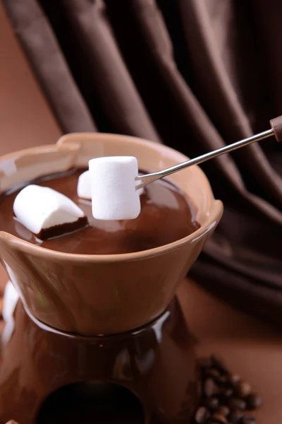 Schokoladenfondue mit Marshmallow-Bonbons auf braunem Hintergrund — Stockfoto