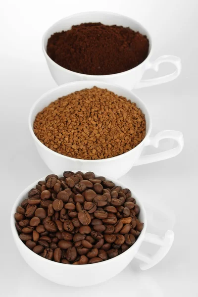 Diferentes tipos de café em três copos isolados em branco — Fotografia de Stock
