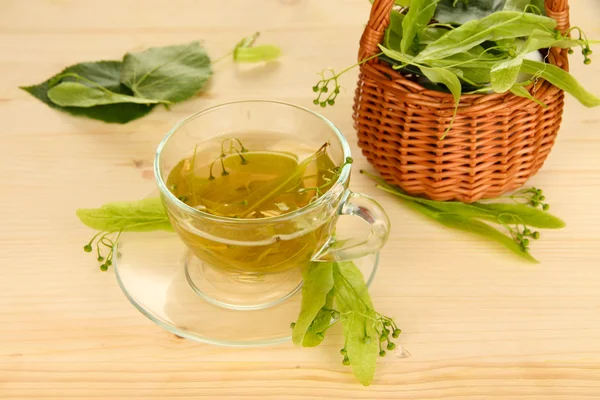 Glass cup of tea with linden on wooden table close-up — Stock Photo, Image