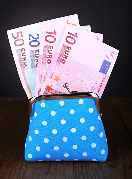 Monedero azul con dinero en la mesa sobre fondo negro —  Fotos de Stock