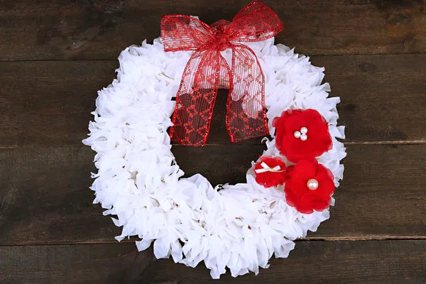 Couronne décorative avec des fleurs sur fond en bois — Photo