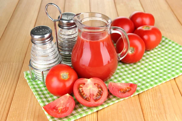 Tomatensap in glazen kan, op houten achtergrond — Stockfoto