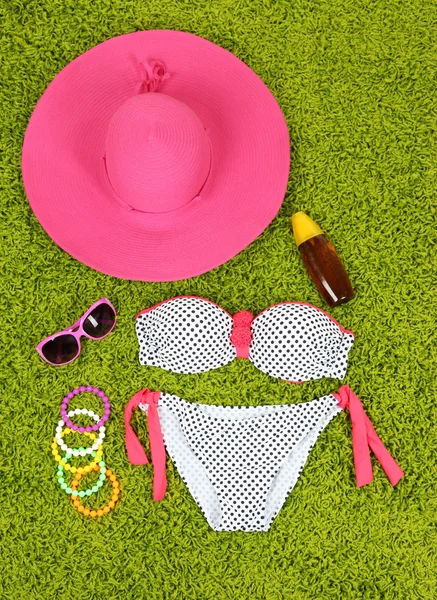 Zwembroek en strand items op groene achtergrond — Stockfoto