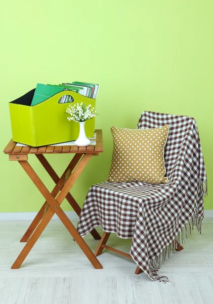 Revistas y carpetas en caja verde sobre mesa en habitación — Foto de Stock