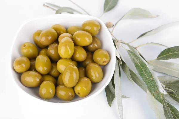 Olive in ciotola con ramo isolato su bianco — Foto Stock