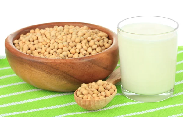 Fèves de soja et verre de lait sur table sur fond blanc — Photo