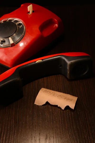 Telefone retro vermelho, no fundo de madeira escuro — Fotografia de Stock