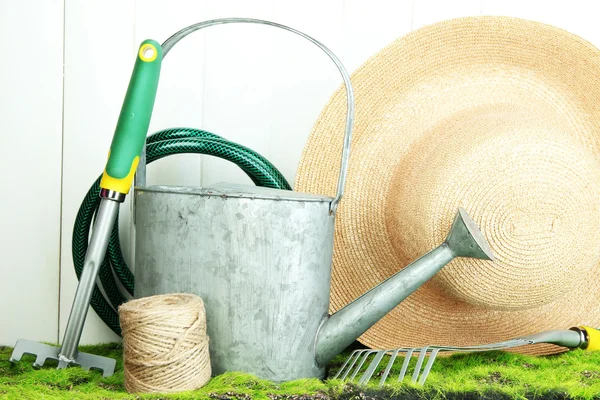 Gardening tools on grass on wooden background — Stock Photo, Image