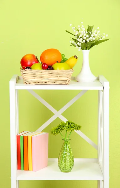 Composition of various home furnishing on white shelf on green wall background — Stock Photo, Image