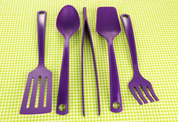 Plastic kitchen utensils on fabric background — Stock Photo, Image