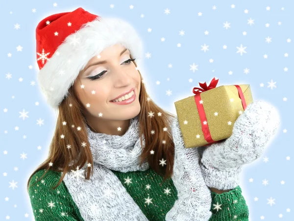 Hermosa chica sonriente en sombrero de Año Nuevo con regalo aislado en blanco —  Fotos de Stock