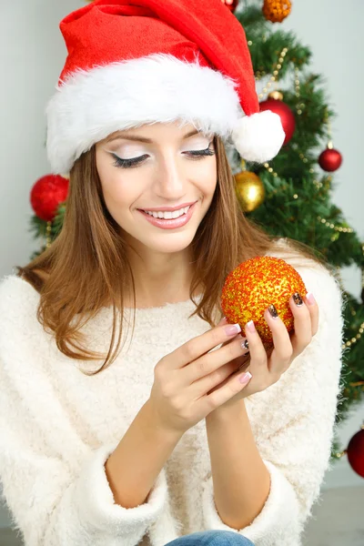 Menina sorridente bonita perto da árvore de Natal no quarto — Fotografia de Stock