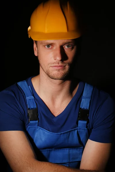 Retrato de jovem trabalhador sobre fundo escuro — Fotografia de Stock