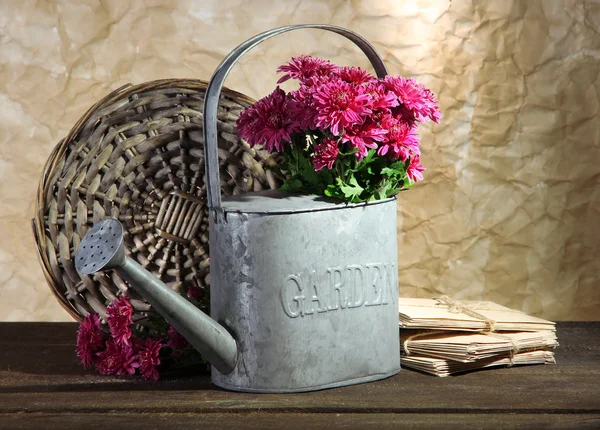 Bouquet of pink chrysanthemum in watering can on wooden table — Stock Photo, Image