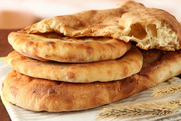 Pita breads with spikes on table on bright background — Stock Photo, Image