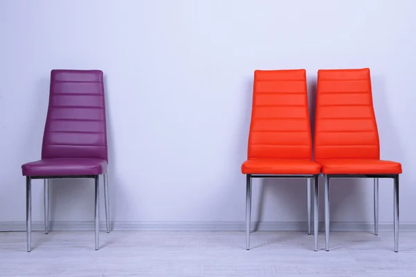 Modern renkli sandalyeler duvar zemin üzerine — Stok fotoğraf