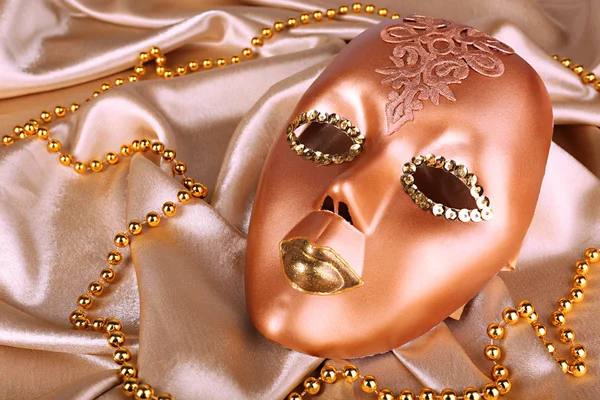 Maske auf goldenem Stoff Hintergrund — Stockfoto