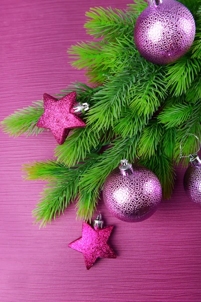 Christmas balls on fir tree, on color background — Stock Photo, Image