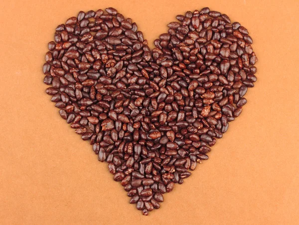 Heart of sunflower grains in chocolate, on brown background — Stock Photo, Image