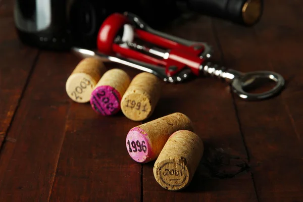 Wine corks with corkscrew on wooden table close-up — Stock Photo, Image