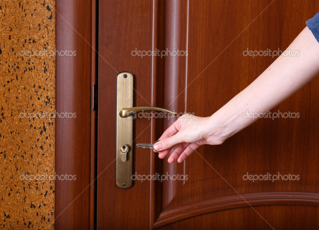 Locking up or unlocking door with key in hand Stock Photo by