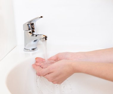 insan elinin altında beyaz izole musluk banyo, yıkandıktan Close-Up