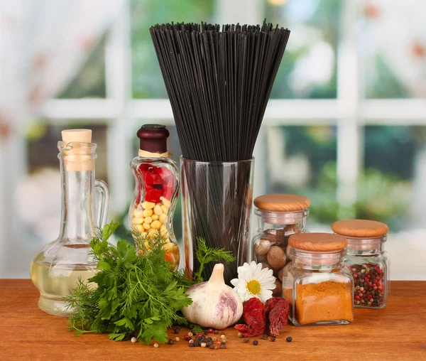 Pasta spaghetti, vegetables and spices on wooden table on bright background — Stock Photo, Image