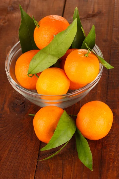 Sweet tangerines with leaves, on wooden background — Stock Photo, Image